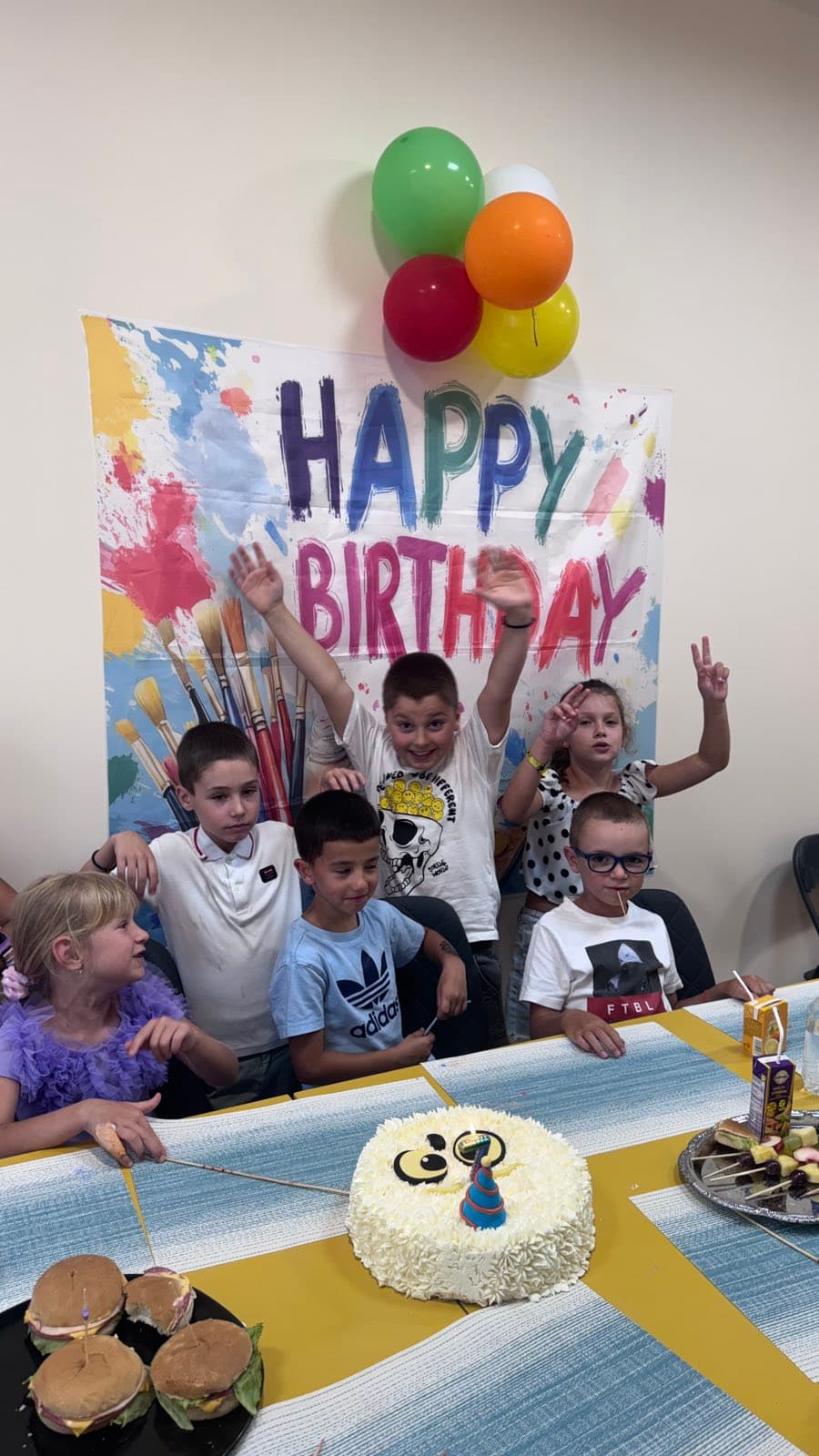 Групова снимка от детски рожден ден в ателието с торта и банер Happy Birthday